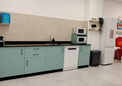 Cocina office equipada con electrodomésticos y armarios verde menta en la Sala Macanaz.